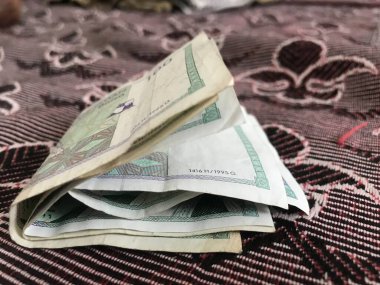 Battaniyenin üzerine katlanmış Umman Sultanlığı 'nın 100 baisa' lık banknotunun görüntülerini kapat.