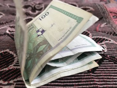 Battaniyenin üzerine katlanmış Umman Sultanlığı 'nın 100 baisa' lık banknotunun görüntülerini kapat.