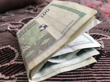 Battaniyenin üzerine katlanmış Umman Sultanlığı 'nın 100 baisa' lık banknotunun görüntülerini kapat.