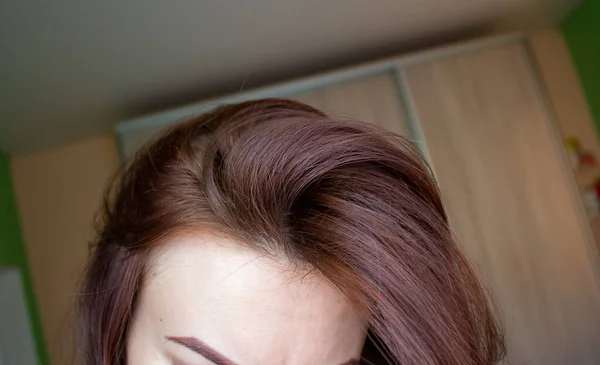 Włosy na kobiecej głowie z bliska. Kolor włosów brązowy. — Zdjęcie stockowe