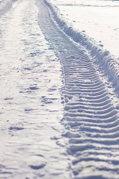Φρέσκα ίχνη από το τρακτέρ στο χιόνι το χειμώνα. — Φωτογραφία Αρχείου