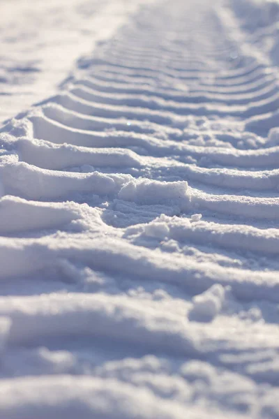 Trilhas frescas do trator na neve no inverno . — Fotografia de Stock