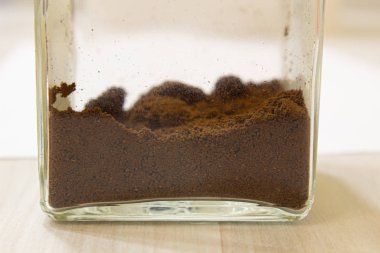 Cam kavanozda öğütülmüş kahve. Kapat.