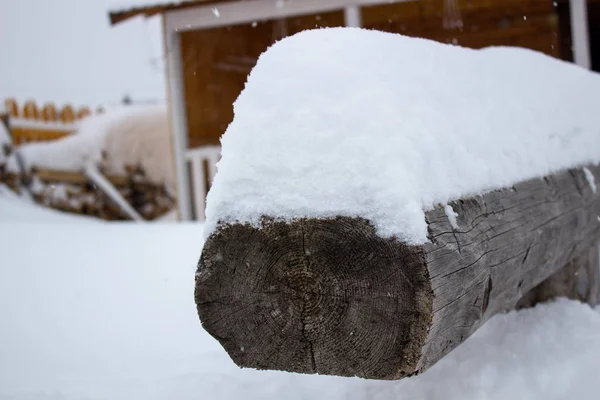 Una viga de madera bajo la nieve. Invierno con nieve . — Foto de Stock