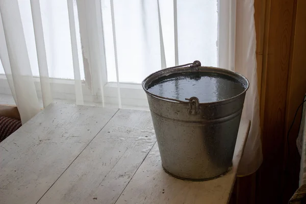 Een emmer water op tafel in de kou. Close-up van een ijsemmer op de achtergrond. — Stockfoto