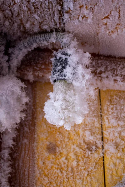 Κρύσταλλοι χιονιού σε έναν ξύλινο τοίχο και μια λάμπα. — Φωτογραφία Αρχείου