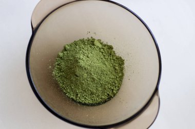 Kınayı ahşap bir kaşıkla karıştırarak doğal renkte saç uygulamak için Hint kınası karışımı gibi.