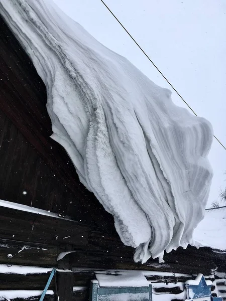 Много снега на крыше дома и зданий. Зима в деревне и в городе . — стоковое фото