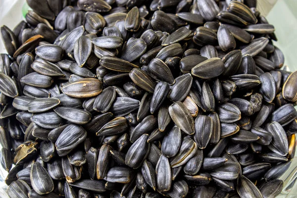 Zwart gebakken zaden in een schaal close-up. — Stockfoto