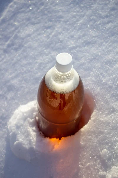 Botella de cerveza de plástico en la nieve en invierno en la naturaleza, fondo de cerveza . —  Fotos de Stock