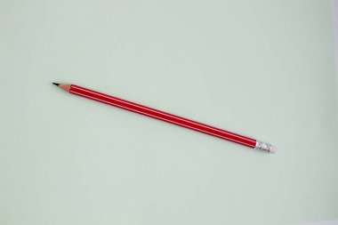 Açık yeşil arkaplanda bir kırmızı kalem.