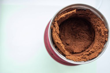 Kahve öğütücüsünden profesyonel bir espresso makinesi için portafilter içine dökülen taze kahvenin yüksek açılı görüntüsü