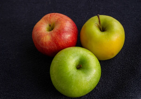Tři Jablka Jedno Zelené Dvě Červené Žluté Tmavém Pozadí — Stock fotografie