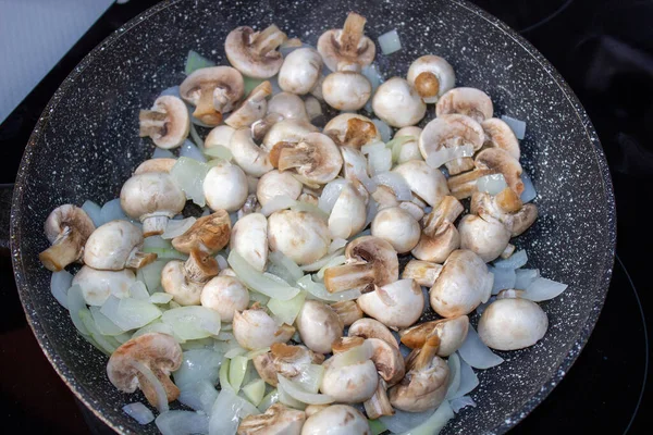 Las setas con la cebolla en la sartén. Preparación del almuerzo y la cena . —  Fotos de Stock