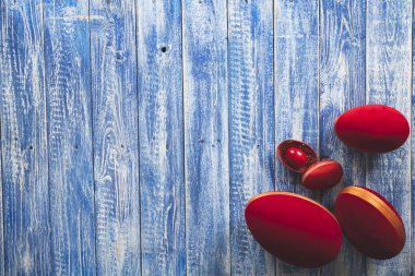 Açık mavi ahşap yüzeyde paskalya kırmızısı dekoratif yumurtalar