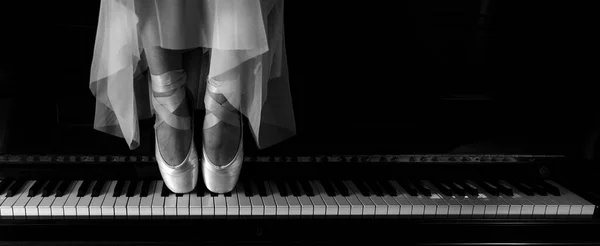 Ballerina standing on a piano. Dark mood concept