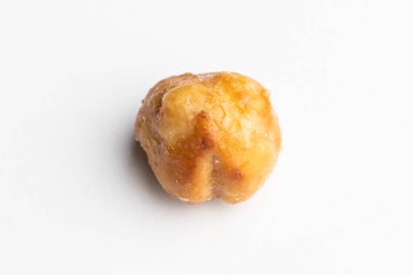 Beyaz bir arka planda izole edilmiş, karamelli büyük bir kavrulmuş fındık.