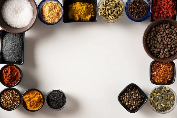 Tuz, siyah susam, haşhaş tohumu, kabak çekirdeği, kırmızı kuru biber, Goji üzümü, köri, kişniş, Bahari, kakule, sarımsak ve zerdeçal içeren farklı şekilli kaseler.