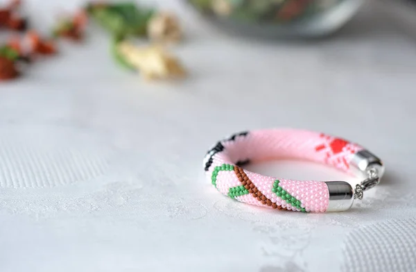 Pink beaded bracelet with the image of a panda close up