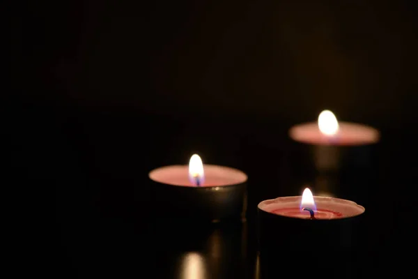 Three burning candles in the darkness — Stock Photo, Image