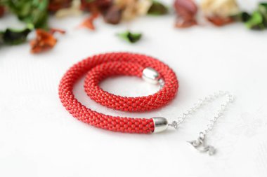 Kırmızı boncuklu kolye Tekstil arka plan yakın çekim