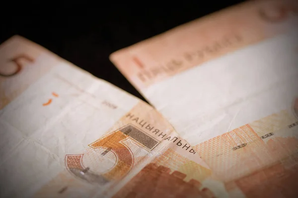 Outdated Belarusian five rubles banknotes on a dark background close up. Retro style