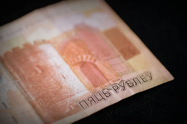 Outdated Belarusian five rubles banknotes on a dark background close up. Retro style