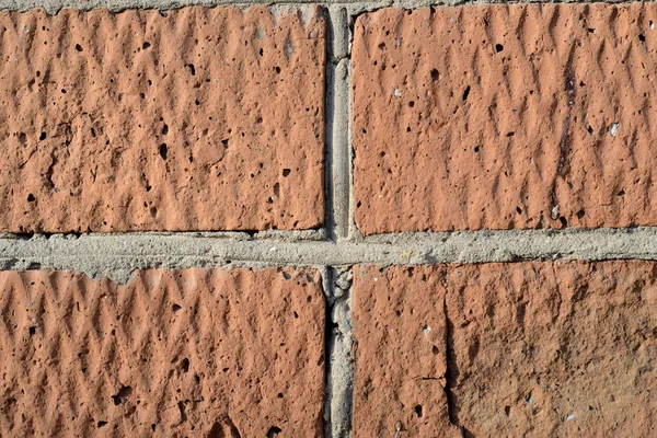 Old red brick wall lit by the sun closeup. Abstract background