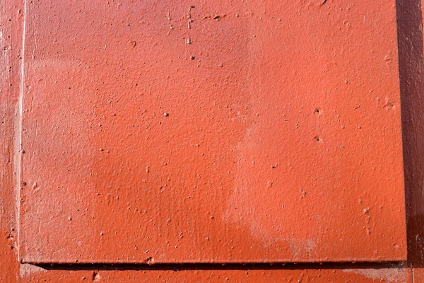 Fragment of an old door painted with brown paint close-up on a sunny day. Abstract background