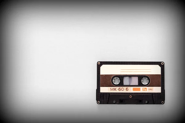 Audio tape cassette on a gray background close-up, top view. Old Technology Concept