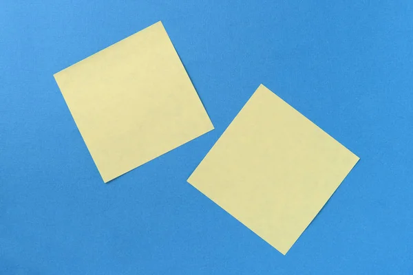 Two yellow sticker notes on a blue background with copy space. Business concept, horizontal mock-up