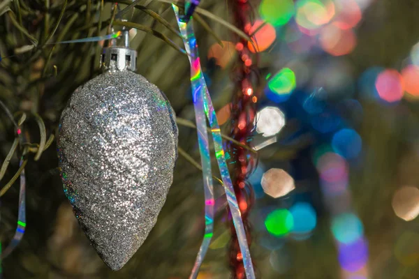 Christmas tree cone silver color on a decorated Christmas tree. Christmas backgroung