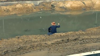 Kirli gölde balık tutan bir adam.