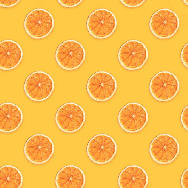 Płynny diagonalny wzór ręcznie suszonych plasterków pomarańczy na modnym żółtym tle. — Zdjęcie stockowe