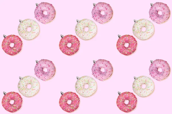 Natal padrão sem costura criativo festivo de linhas diagonais de donuts como brinquedos de árvore de Natal no fundo rosa . — Fotografia de Stock
