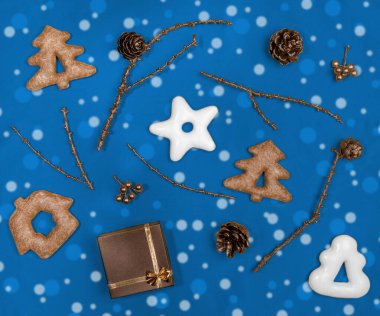 Moda 2020 Klasik Mavi 'nin Noel düz düzeni. Zencefilli çörek, bronz boyalı dallar, koniler ve hediye kutusu.. 