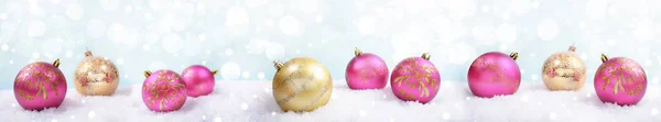 Праздничный рождественский баннер с розовыми и золотыми рождественскими шарами на светлом фоне со снегом и боке. Селективный фокус . — стоковое фото