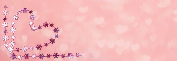 Creative Valentines day banner. Heart of shiny lilac snowflakes on gentle pink background with bokeh in hearts shape. — ストック写真