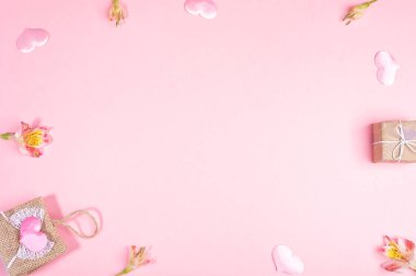 Hasır çanta çerçevesi, hediye kutusu, pembe kalpler, pembe arka planda Alstroemeria çiçekleri. Sevgililer Günü Şenlik Mekanı. 