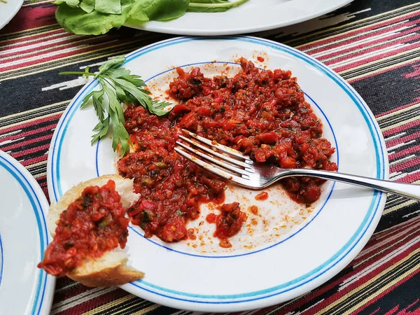 Spicy paste from red chili harissa sauce on white plate and on piece of bread. — Stock Photo, Image