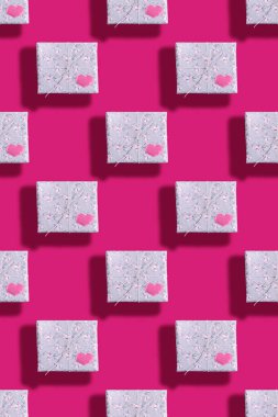 Gri kağıda sarılı kusursuz hediye kutuları. Çiçek desenli. Pembe kalpli ve parlak pembe gölgeli.. 