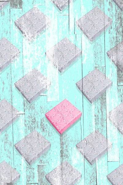 Creatief naadloos diagonaal patroon met één roze geschenkdoos onder grijze met turquoise Zine getextureerde overlay. — Stockfoto