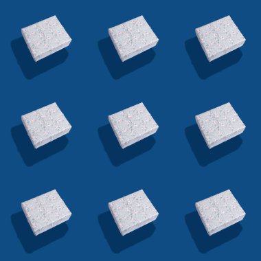 Gri kağıda sarılı, kusursuz hediye kutuları deseni. Klasik mavi arka planda gölgeler var..