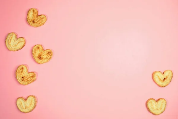 ハート型のクッキーとコピースペースを真ん中に持つトレンディなピンクのパステルの背景。バレンタインデーのための休日のペストリー. — ストック写真