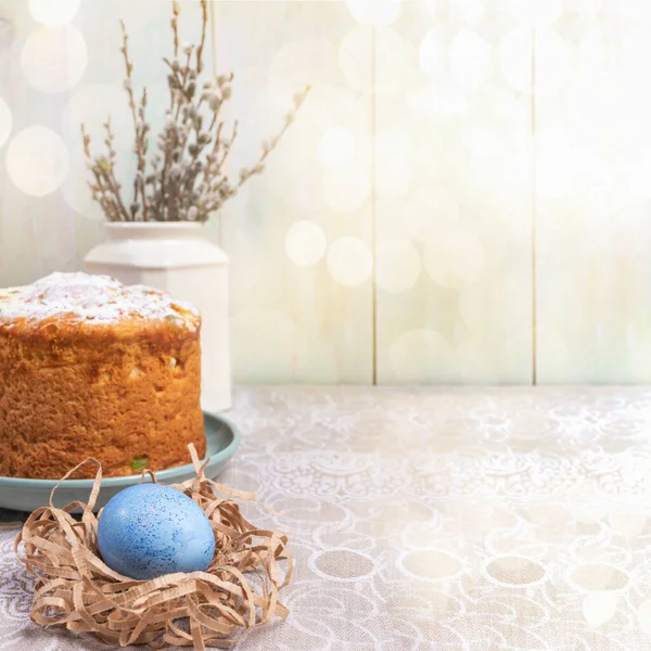 Пасхальный фон с боке, пасхальный торт, голубое яйцо, ивовые ветви на столе у деревянной стены с копировальным пространством . — стоковое фото