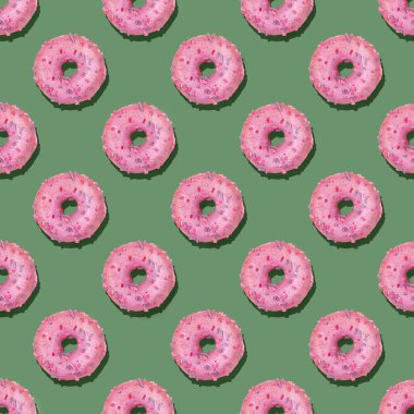 Sakin yeşil arka planda leylak jöleli geleneksel donutların modaya uygun ve pürüzsüz deseni. Sert gölgeler. 