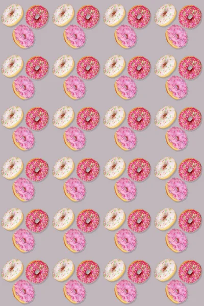 Trendiges, nahtloses Muster traditioneller Donuts mit lila, weißen und lila Glasuren auf Grau. Vertikale Orientierung. — Stockfoto