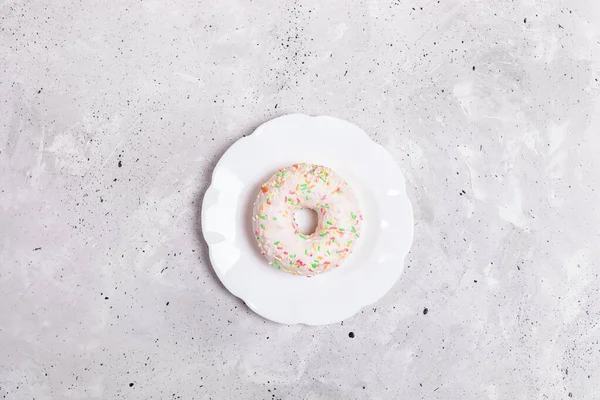 Una Rosquilla Acristalada Blanca Está Acostada Una Placa Blanca Centro —  Fotos de Stock