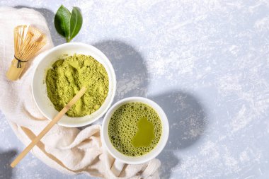 Kibrit yeşil çay fincanı ve pudra kasesi, tahta kaşık, bambu çırpısı, gri desenli peçetedeki taze yapraklar.. 