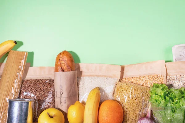 Склад пищевых продуктов в экологически чистых упаковках и фруктах, выложенных на зеленый. Без пластика. Карантинные акции. Копирование пространства . — стоковое фото